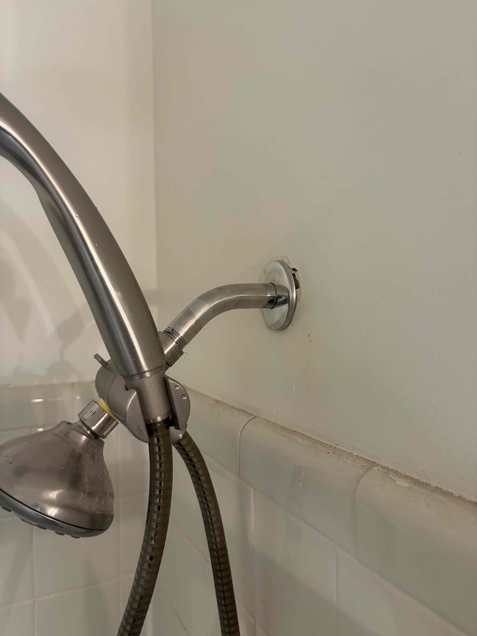 Upon arrival, customer stated is experiencing a leak coming down from kitchen ceiling. Found access panel behind master shower. Inspected shower, found leak coming from showerhead. Had to cut another access hole to expose leak fully. Found leak coming from shower arm. Replaced leaking plastic shower arm. Shower is no longer leaking at departure. Customer signed up for Win With Chen!