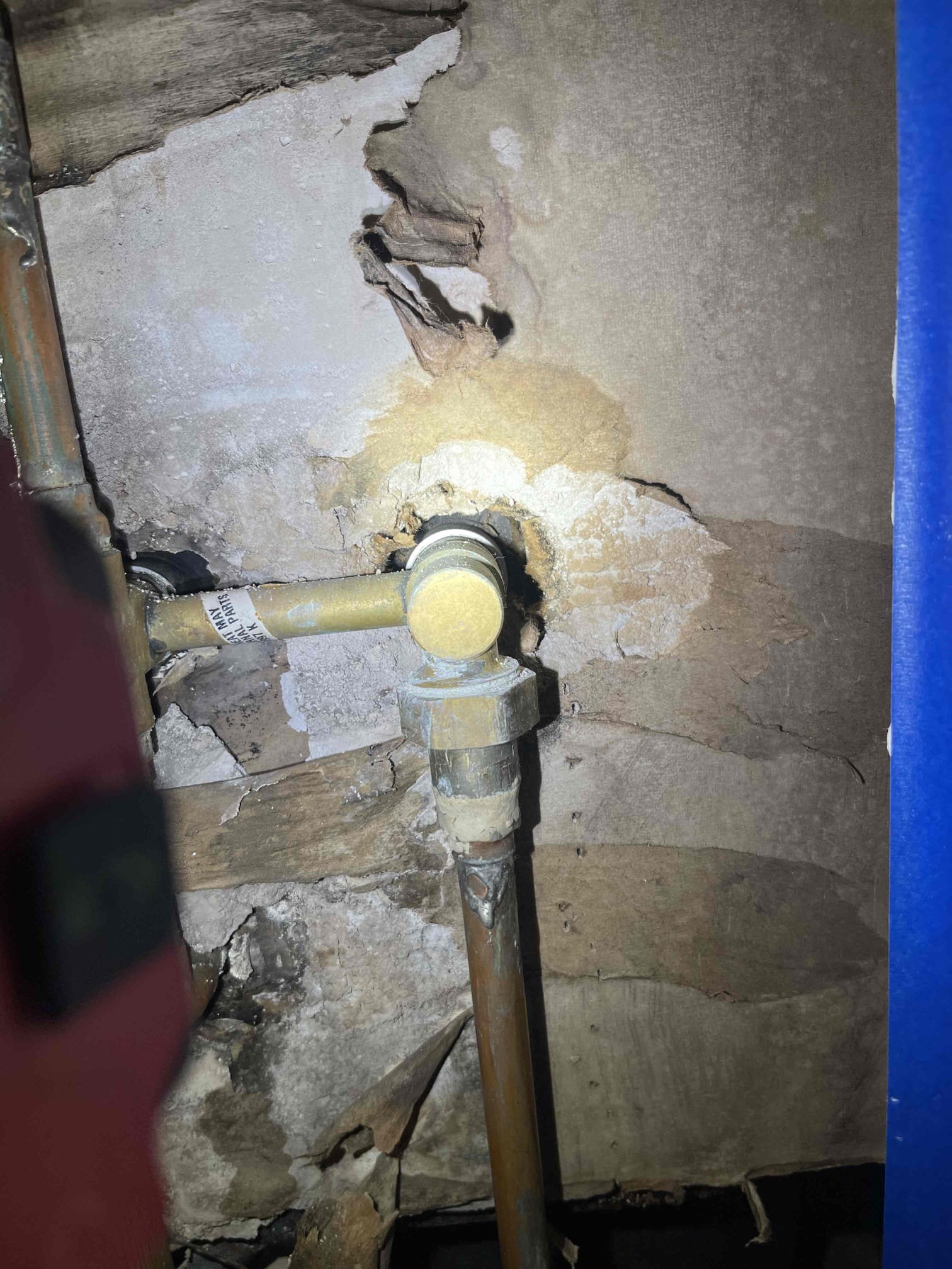 Came out for a possible secondary leak on a shower another tech recently repaired. Previous tech replaced a leaking shower arm and tested the shower and found no leaks. Customer stated after he used the shower for the first time again, he noticed a small amount of water had pooled on the plastic where they had cut the ceiling open below the tub. Leak was due to inadequate caulking on the left/hot side handle of the shower valve. When someone was in the shower, water would bounce off and run down the wall and slowly leak behind the trim plate and run down the outside of the tub before pooling up and dripping down below. This is not a new issue as seen from the video and pictures as where the water is pooling is heavily rusted in that spot alone. Demonstrated the leak to the homeowner by spraying water on the wall with the shower head so he could see the leak occurring. He is going to have his contractor waterproof the shower as part of the remediation process. 