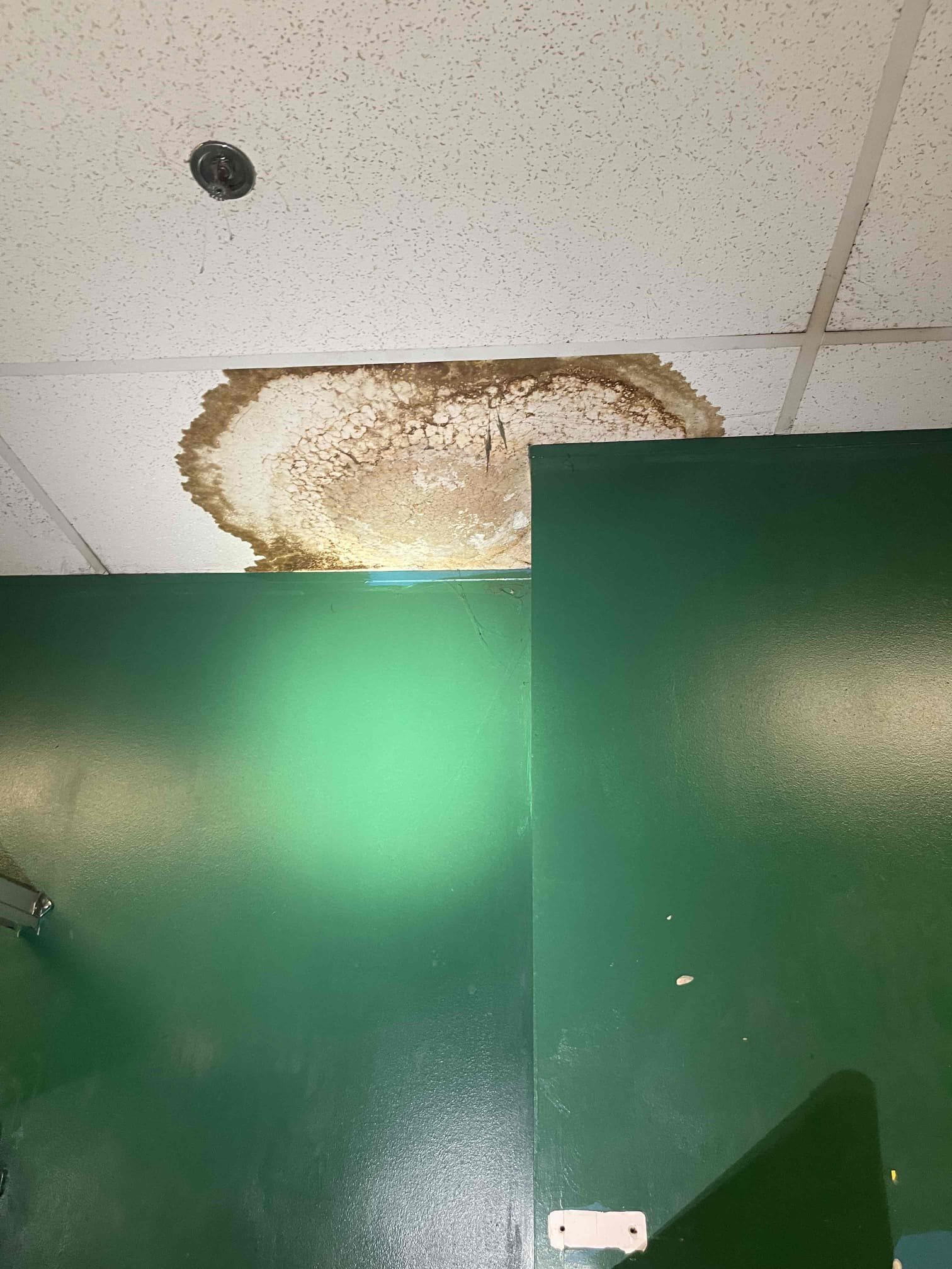 Came out for a leak in the ceiling of a warehouse. Building owner directed us to the men’s restroom ceiling in the warehouse. The tile was heavily saturated and collapsed as soon as I touched it. We looked in the ceiling and found a small water heater for the sinks. Went over to the women’s restroom to get closer to the tank. Examined tank and found it was still working, and there were no leaks. Water heater pan was dry and full of dust. T&p drain piping was cold to the touch. No sign of any plumbing leak. There was an exhaust fan pulling cold air from the inside restroom that is directly over the damaged ceiling tile. Believe this was condensating in the hot warehouse air and dripping onto the ceiling tile. 