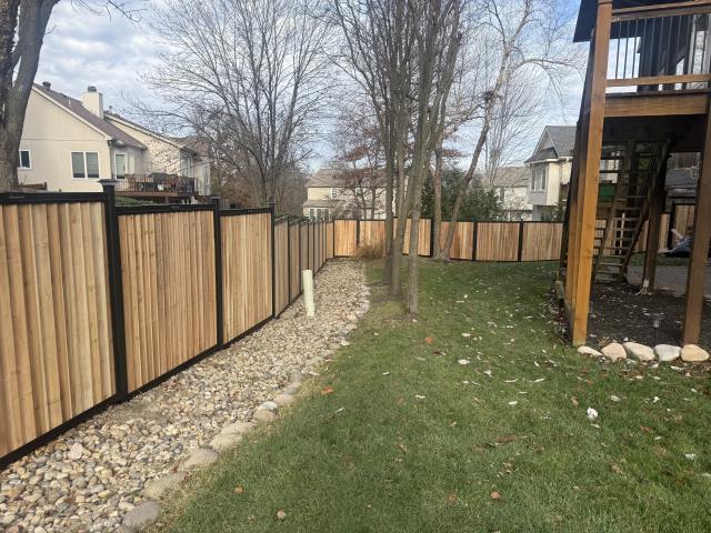 Kansas City, MO -  Top Rail Fence replaced the old, worn-out fence with a brand-new cedar slip fence, with black metal posts and top and bottom rails.