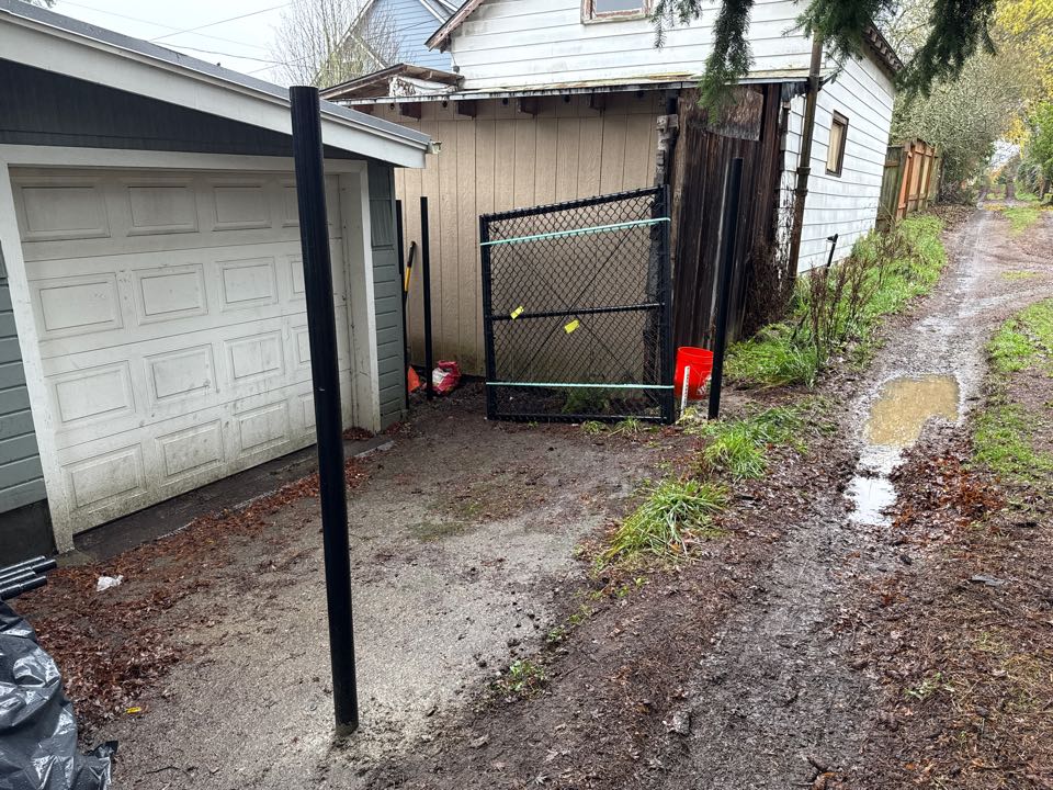 Seattle, WA - Chain link going up in Crown Hill on a rainy day.