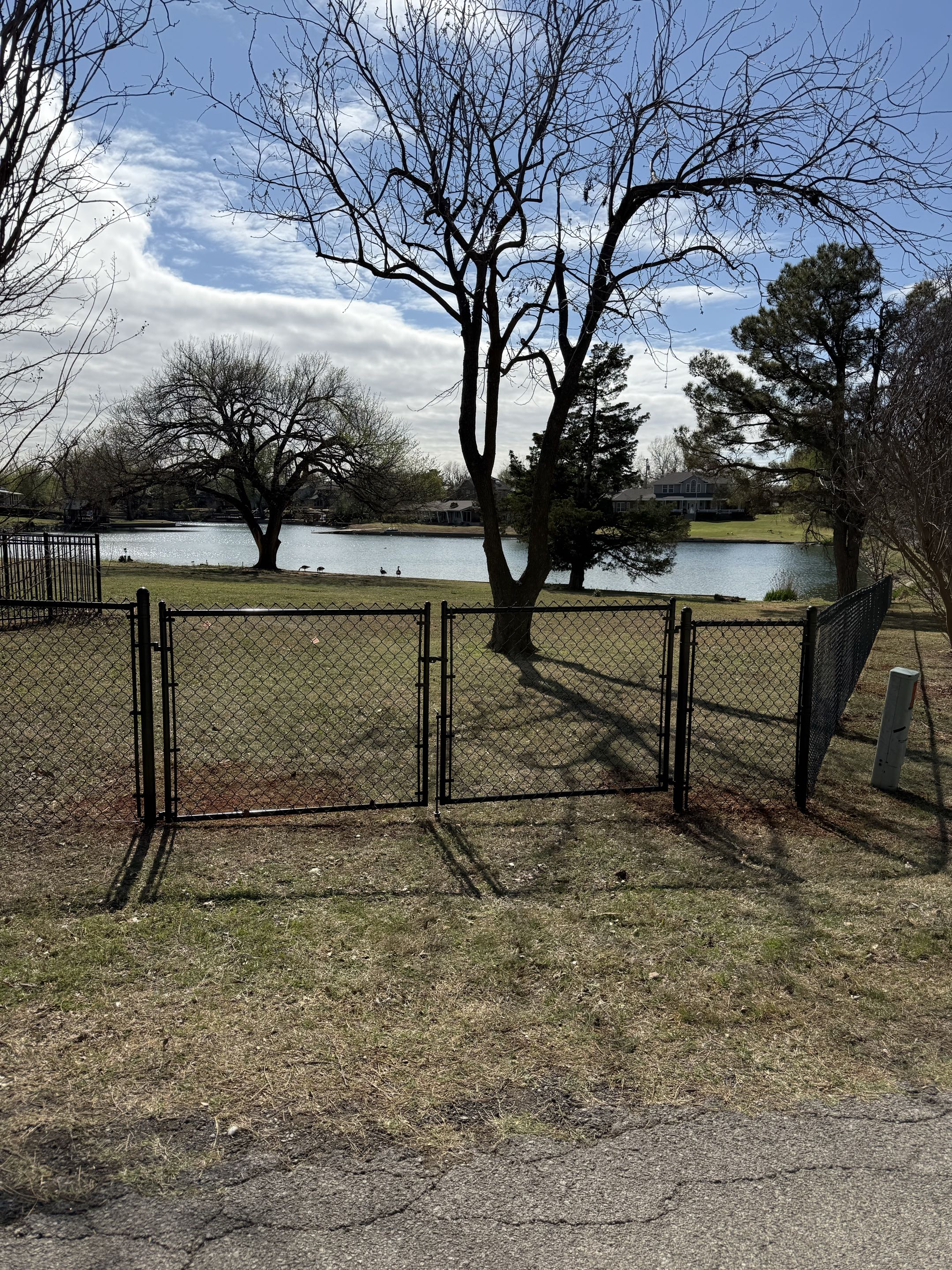Oklahoma City, OK - Another clean black chain link fence wrapped up! This 4 ft tall black chain link fence beautifully fits this property allowing the homeowner to enjoy their beautiful backyard pond. 