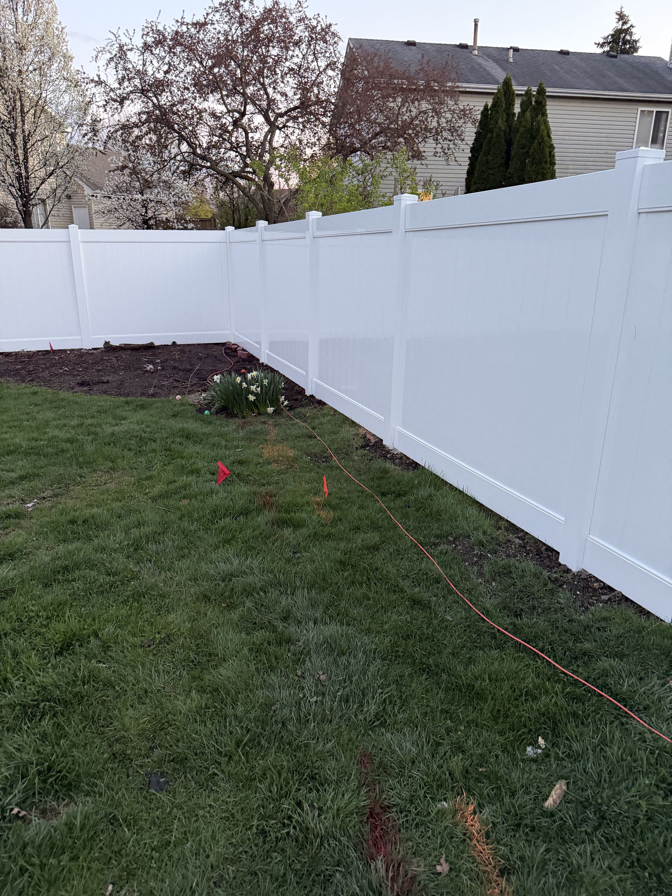 Naperville, IL - A homeowner sought to replace their deteriorating wood fence with a low-maintenance option. They opted for a 6’ white vinyl fence, drawn to its durability and aesthetic appeal. The homeowner chose our services after being impressed by the quality of work we delivered for their neighbor. We began by removing the old fence, ensuring a clean slate for the new installation. We meticulously measured and marked the area for precise placement of the vinyl panels. Each panel was carefully installed, ensuring a seamless and sturdy structure. The final result was a beautiful, low-maintenance fence that enhanced the home's curb appeal. The homeowner was delighted with the transformation and the hassle-free maintenance that comes with vinyl fencing.