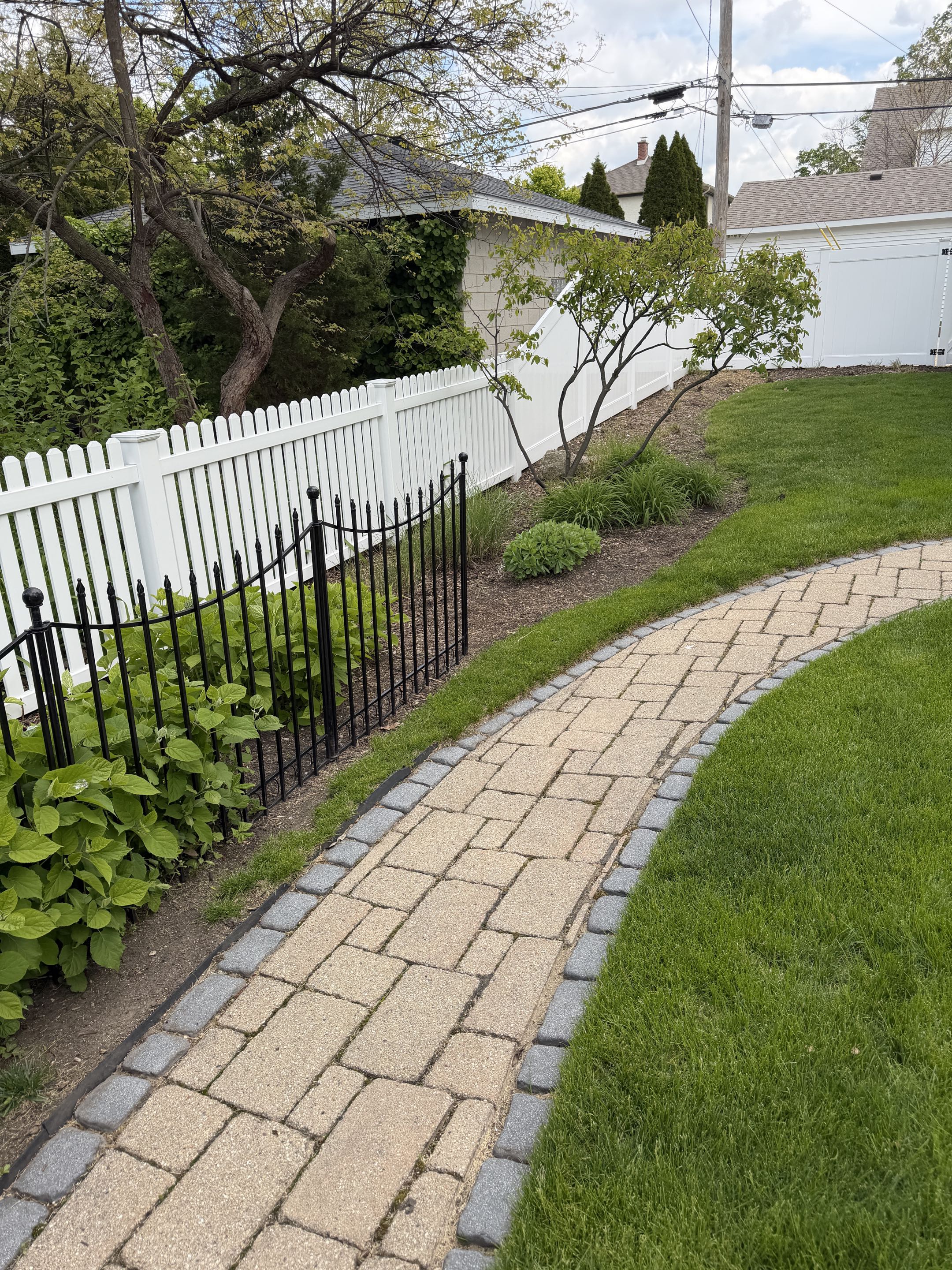Wheaton, IL - A recent project involved installing a new fence for a client. The design incorporated a blend of white vinyl pickets and white privacy vinyl sections, creating a seamless and visually appealing transition between the two. The white vinyl pickets provided a classic, elegant look, while the privacy vinyl ensured the client's desired level of seclusion. The custom transition was meticulously crafted to ensure both aesthetic harmony and structural integrity. The project was completed to the client's satisfaction, enhancing their property's curb appeal and privacy.
