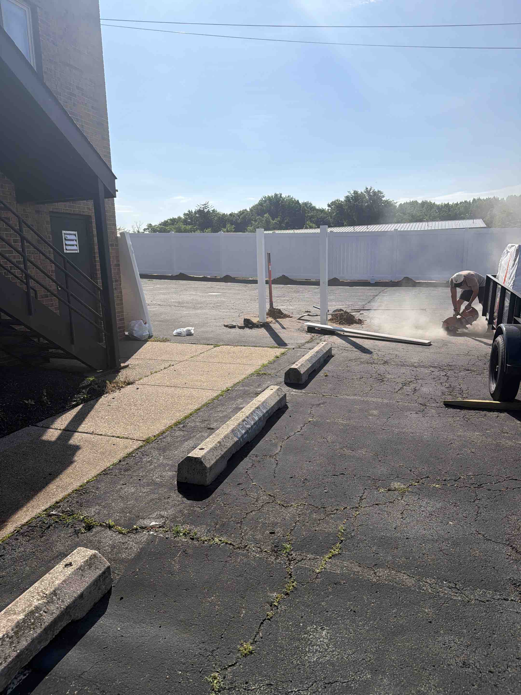 Cherry Hill Township, NJ - Building out a privacy white vinyl fence on asphalt for a preschool’s upcoming playground area.