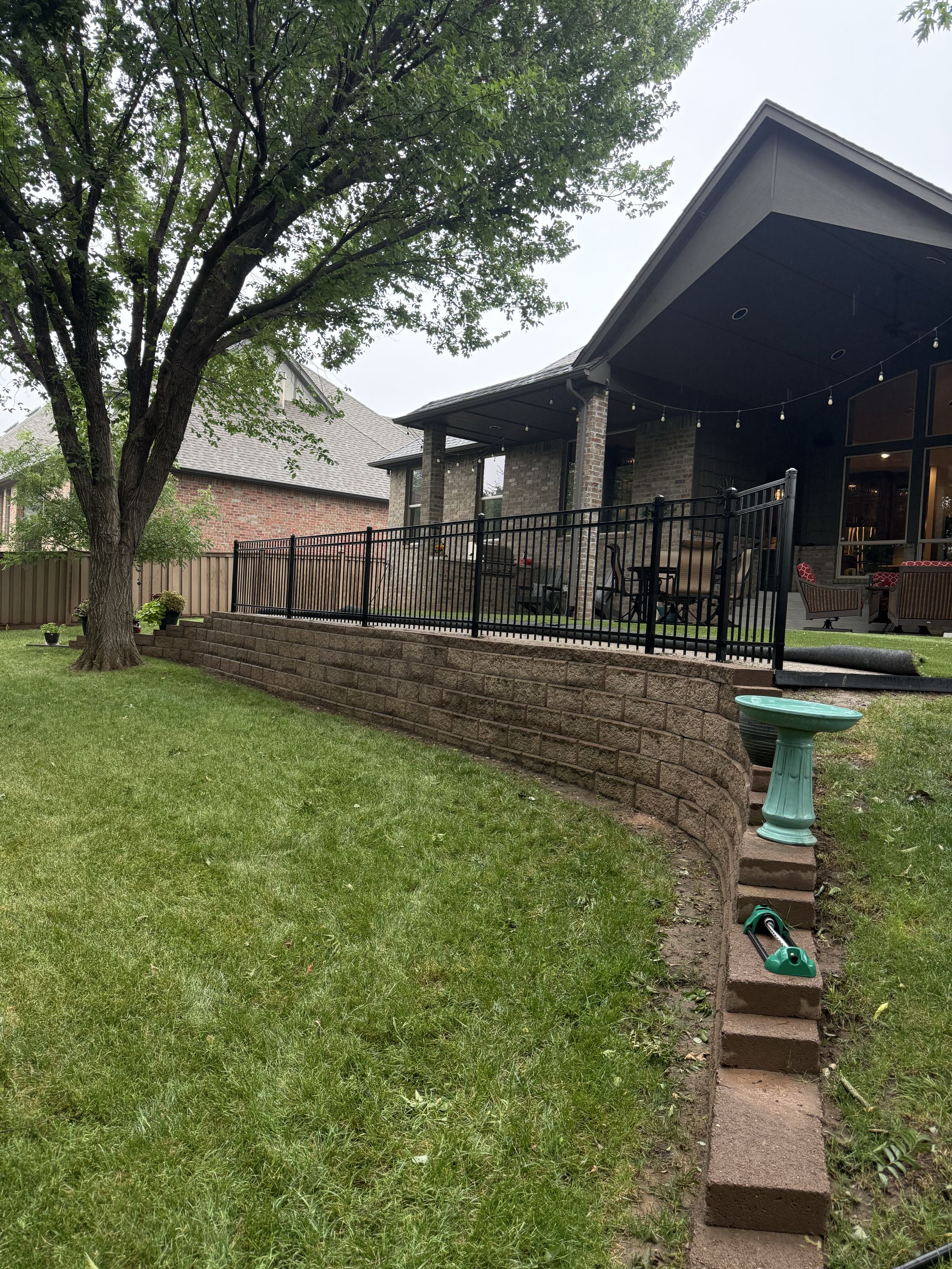 Edmond, OK - Installed a 4-foot-tall 3-rail flat top ornamental fence along a retaining wall to add an extra layer of safety without blocking the view. The clean, elegant design complements the landscape while helping protect children and pets around the elevated area.