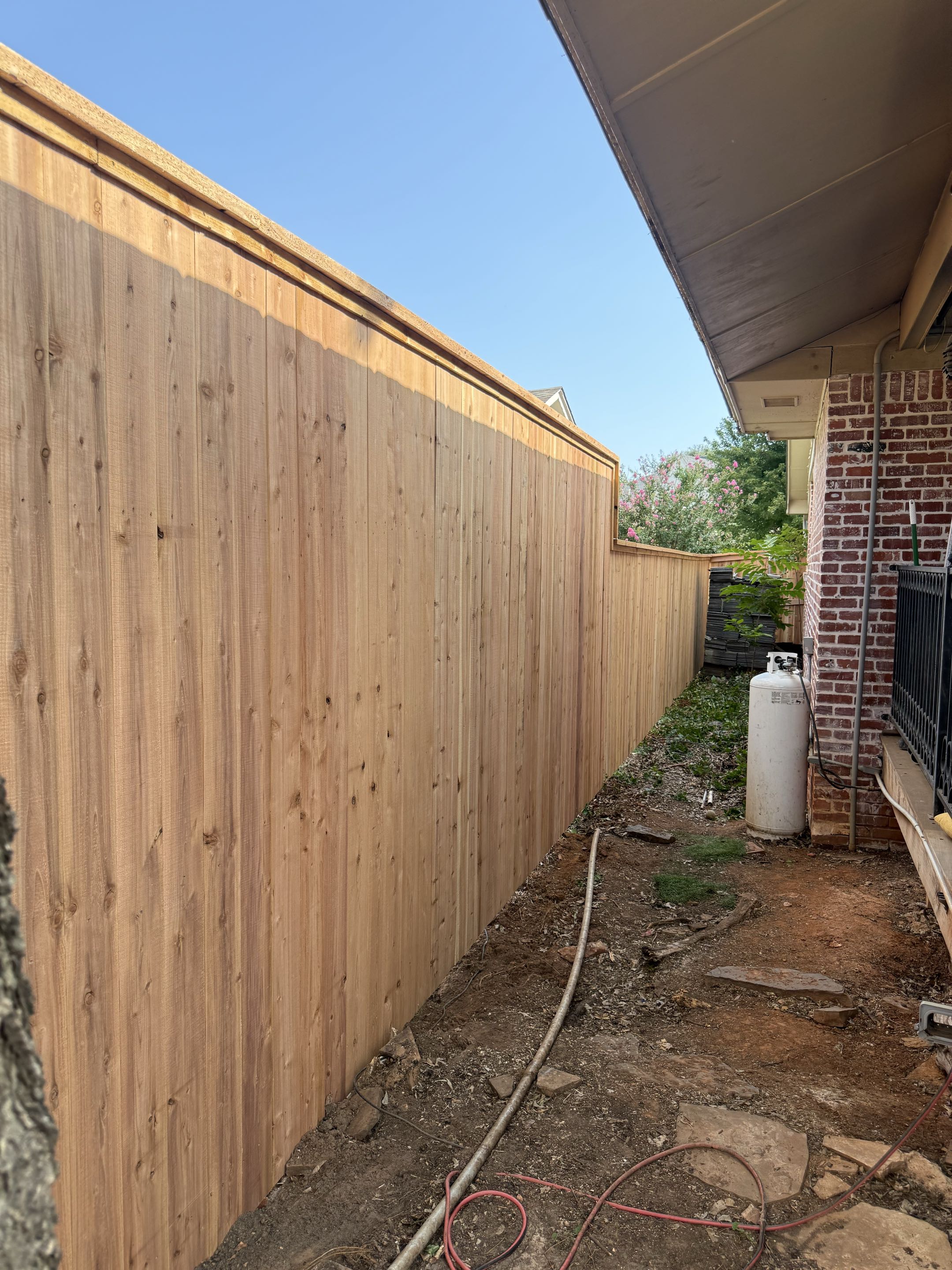Oklahoma City, OK - Another quality fence in the books! This custom Japanese Cedar fence features a 6’ to 8’ height transition with a cap and trim finish, giving the homeowner additional privacy and a polished look that will stand the test of time.
