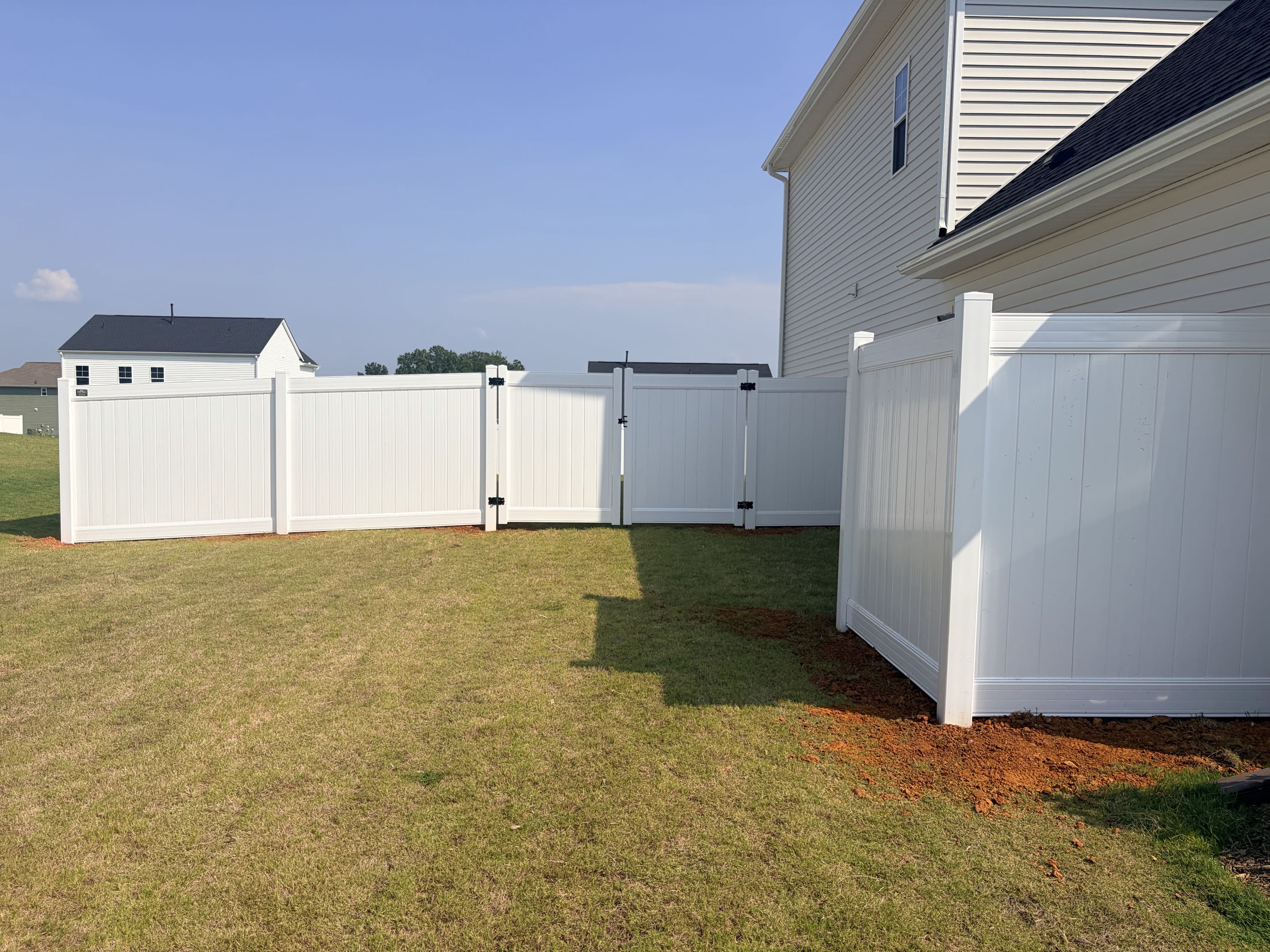 Garner, NC - We installed 286 linear feet of white vinyl privacy fence, standing six feet tall, to enhance the property's curb appeal and ensure safety. The fence features two sturdy gates for easy access and a cleverly designed trashcan hide to maintain a neat appearance. This project provides a secure environment for the family's children while seamlessly blending with the property's aesthetic. The high-quality materials and precise craftsmanship guarantee durability and long-lasting beauty.