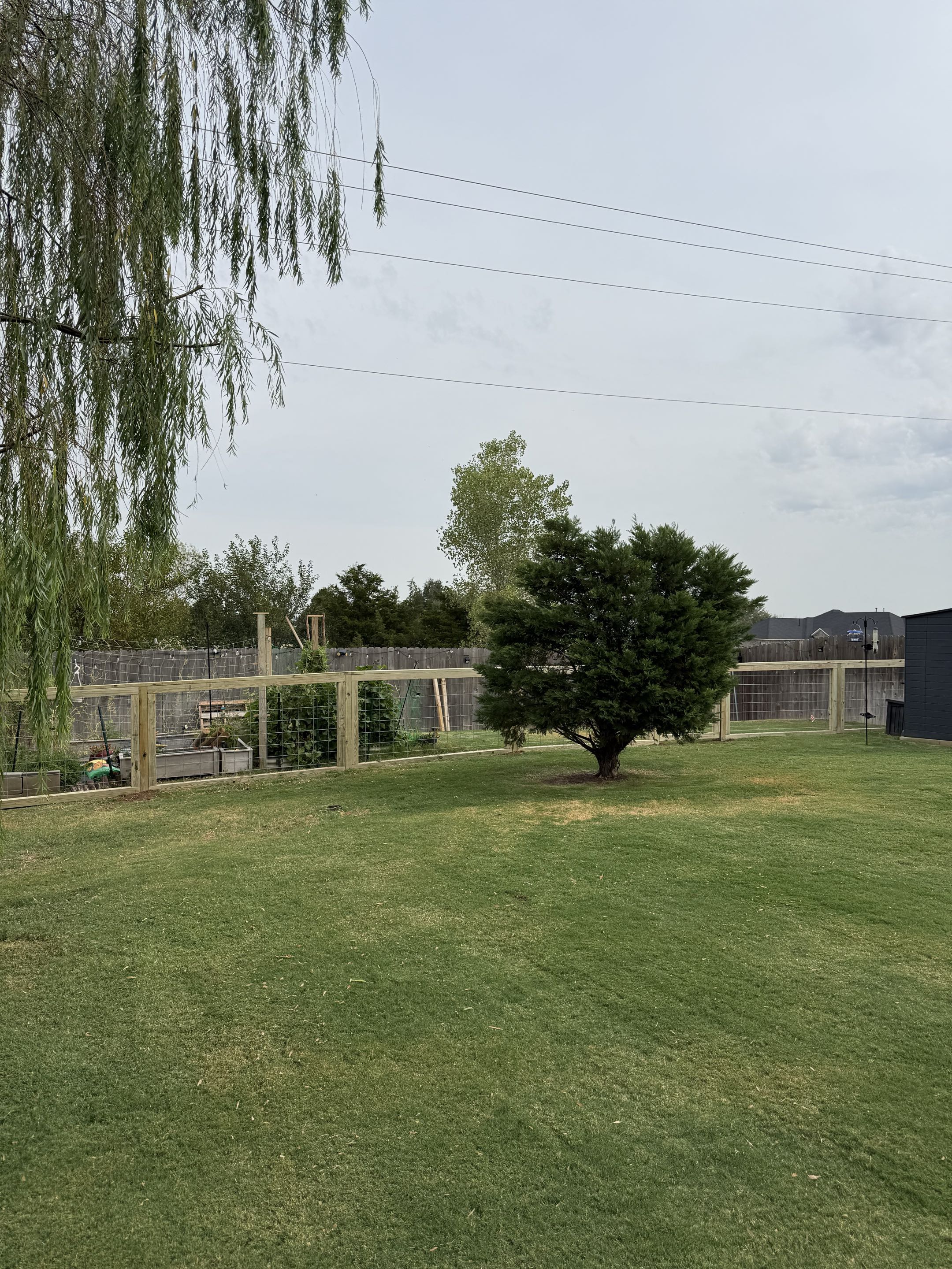 Yukon, OK - A custom 4 ft agricultural fence featuring hog panels, designed to keep pets out of the garden while adding a clean, attractive touch to the yard.