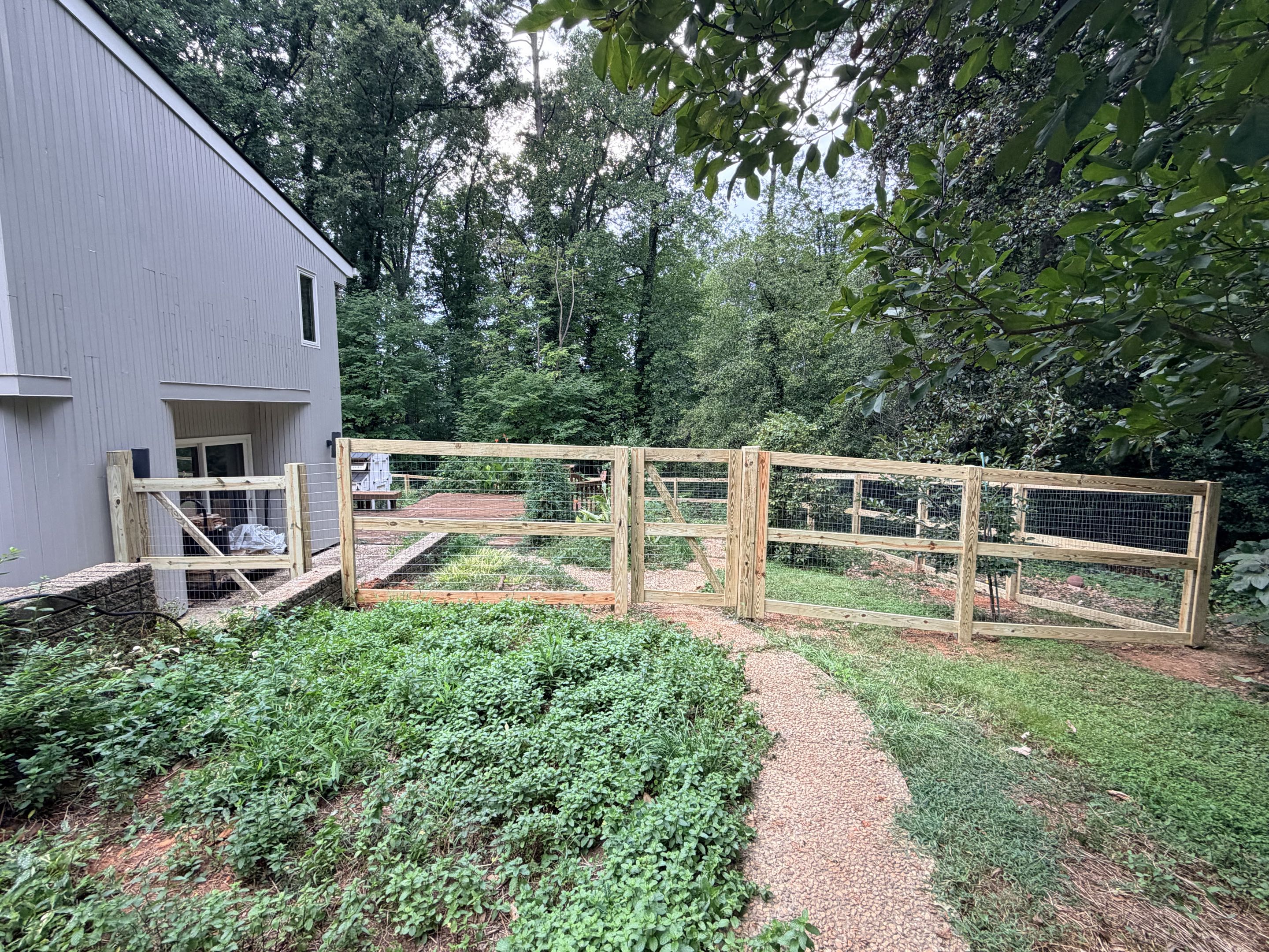 Raleigh, NC - We completed a project involving the installation of 350 linear feet of 6H wood and wire fencing, designed to securely contain pets and keep wildlife out. The fencing was meticulously constructed with high-quality materials, ensuring durability and effectiveness. Four pedestrian gates were installed to provide convenient access, while one double gate was added for larger vehicles or equipment. Each gate was carefully positioned to maintain the integrity of the fence while allowing for easy passage when needed. The project was executed with precision, resulting in a robust and reliable barrier that meets the client's needs for pet containment and wildlife exclusion.
