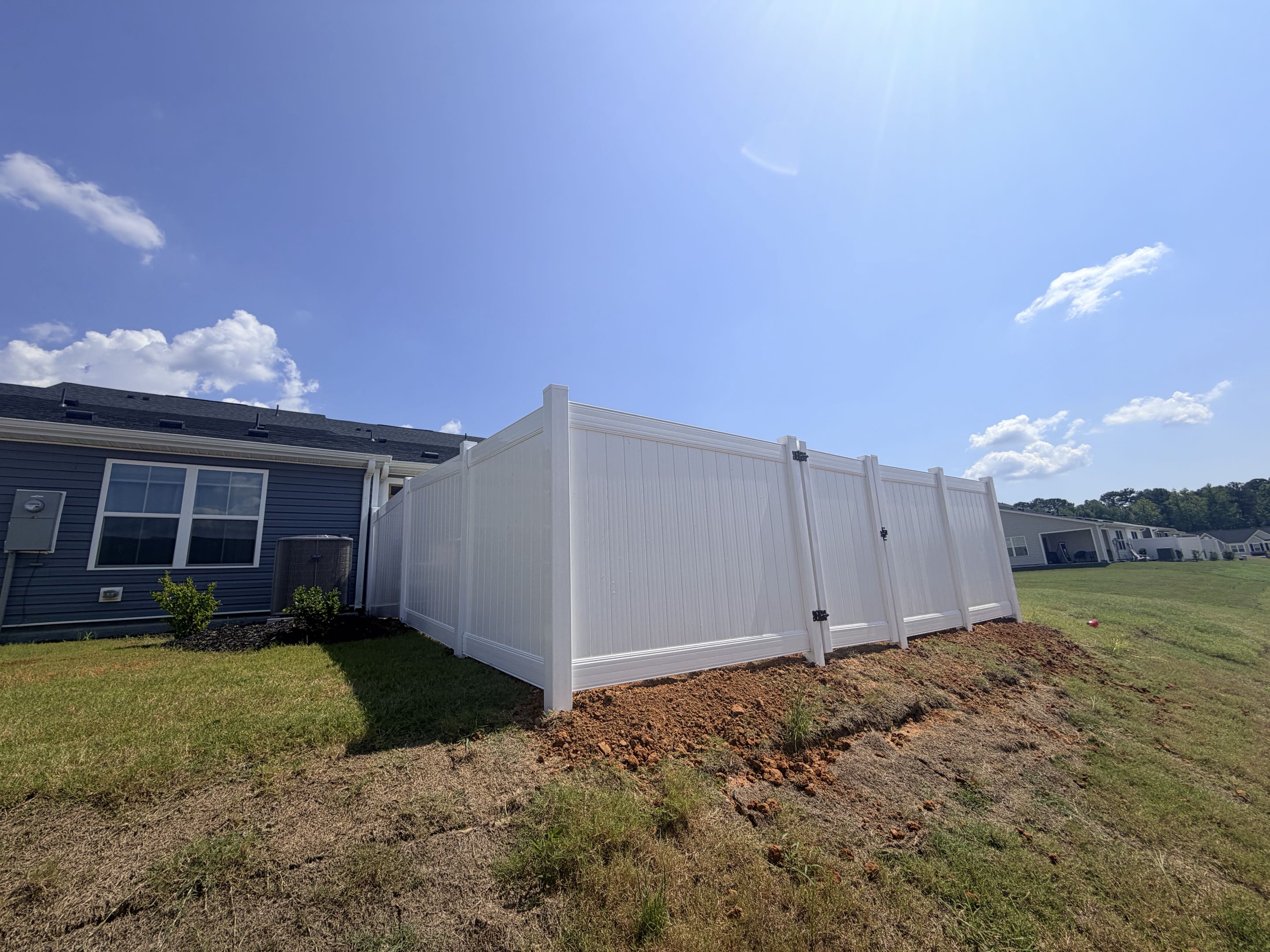 Raleigh, NC - We meticulously installed a 52-linear-foot section of a 6-foot-high white privacy vinyl fence, ensuring a seamless blend of durability and aesthetics. The vinyl material was chosen for its low maintenance and resistance to weathering, providing long-lasting protection. A single gate was incorporated to allow easy access while maintaining the fence's privacy function. The installation process involved precise measurements, secure anchoring, and careful alignment to ensure stability and uniformity. This project successfully enhanced the property's security and created a safe environment for the resident's dogs, offering them a peaceful and enclosed space to play.