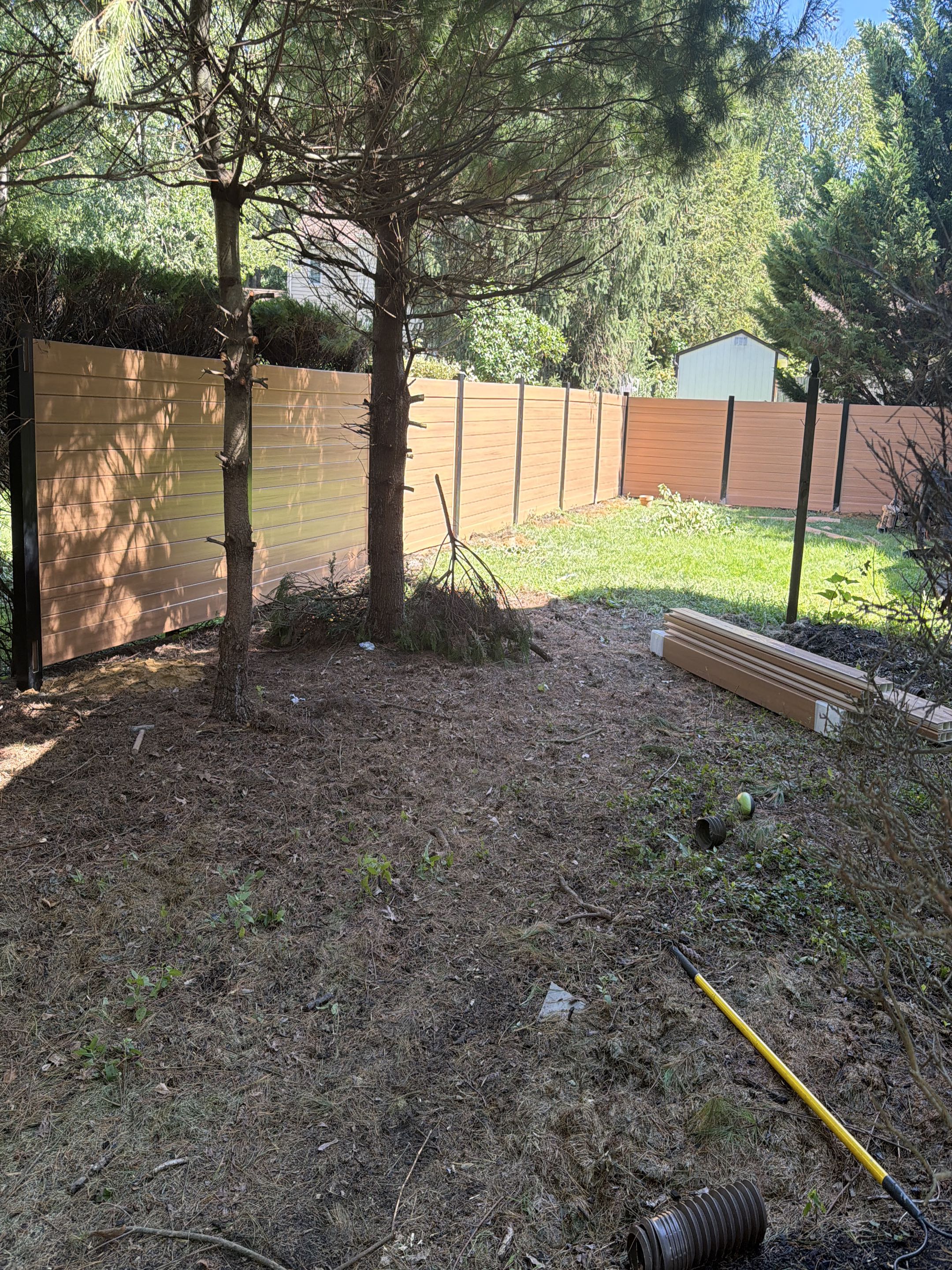 Cherry Hill Township, NJ - Cypress wood grain vinyl fence with black posts bring installed today. An absolute stunner!