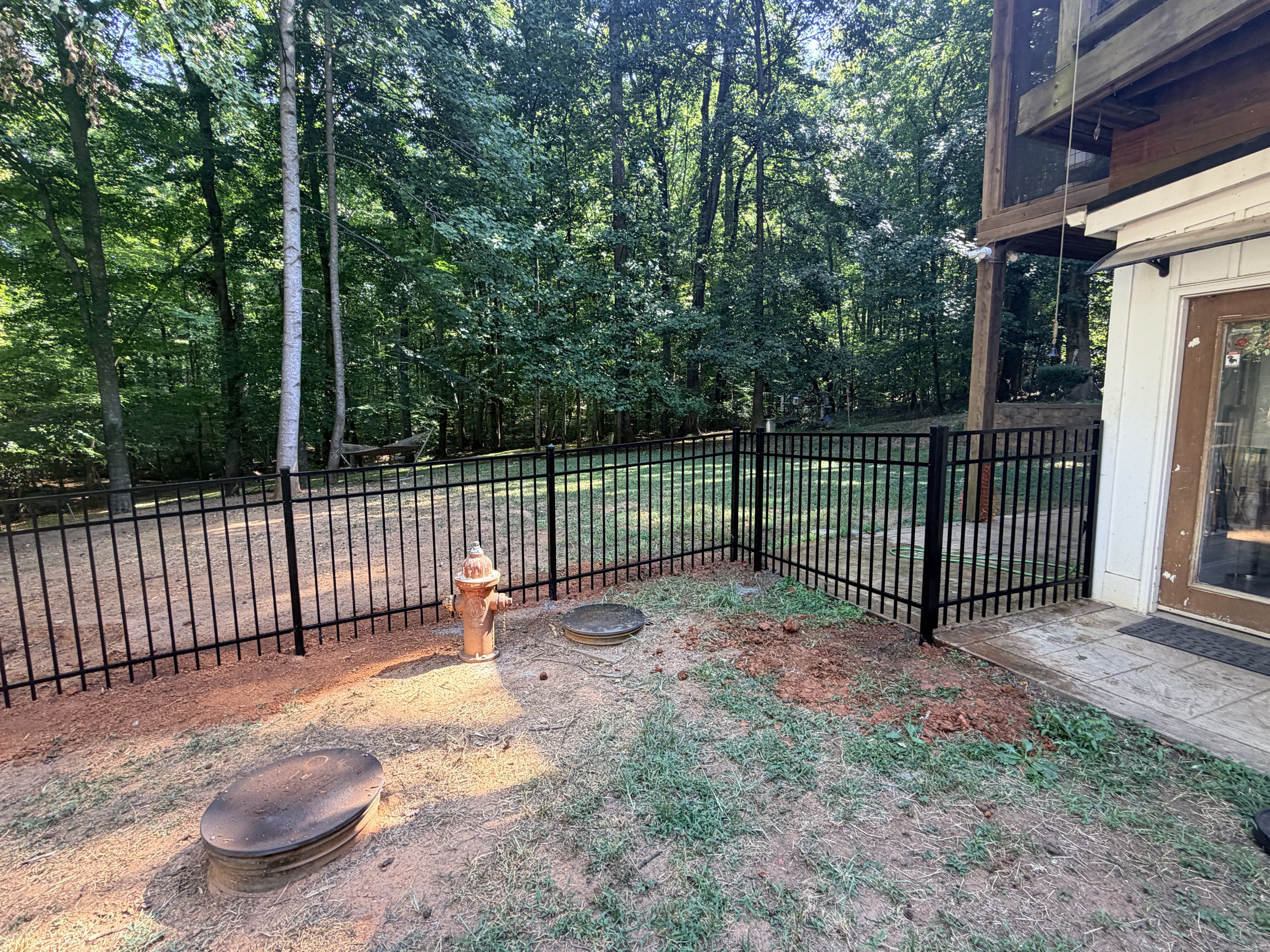 Raleigh, NC - Our team installed a 60-foot stretch of 4-foot high, 3-rail aluminum fencing, ensuring a secure environment. The fencing features one single gate and one double gate, providing ample access while maintaining safety. This installation was designed to keep four dogs secure, offering peace of mind to the owners. The high-quality aluminum material ensures durability and resistance to the elements. The gates were installed with precision to allow easy entry and exit for the dogs while preventing any escape. This project was completed with attention to detail, ensuring a perfect fit and seamless integration with the existing landscape.