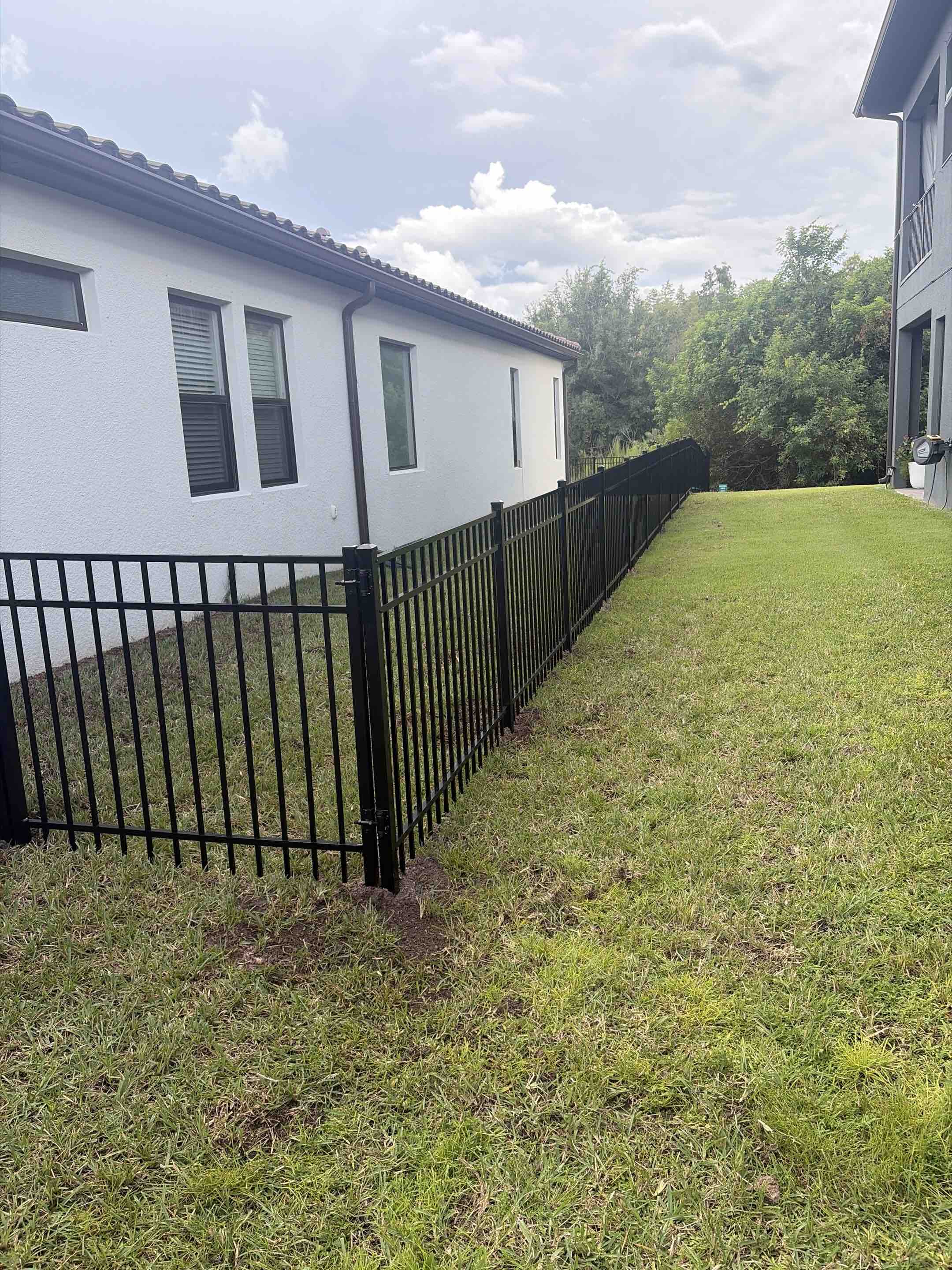Odessa, FL - A stunning black ornamental fence was meticulously crafted and installed, showcasing intricate designs and superior craftsmanship. Each panel was carefully selected for its aesthetic appeal and durability, ensuring a timeless look. The installation process involved precise measurements and expert handling to guarantee a perfect fit and alignment. Attention to detail was paramount, with each joint and connection flawlessly executed. The final result is a fence that not only enhances the property's curb appeal but also stands as a testament to exceptional quality and artistry. The elegant black finish complements the surrounding landscape, creating a harmonious and sophisticated appearance.