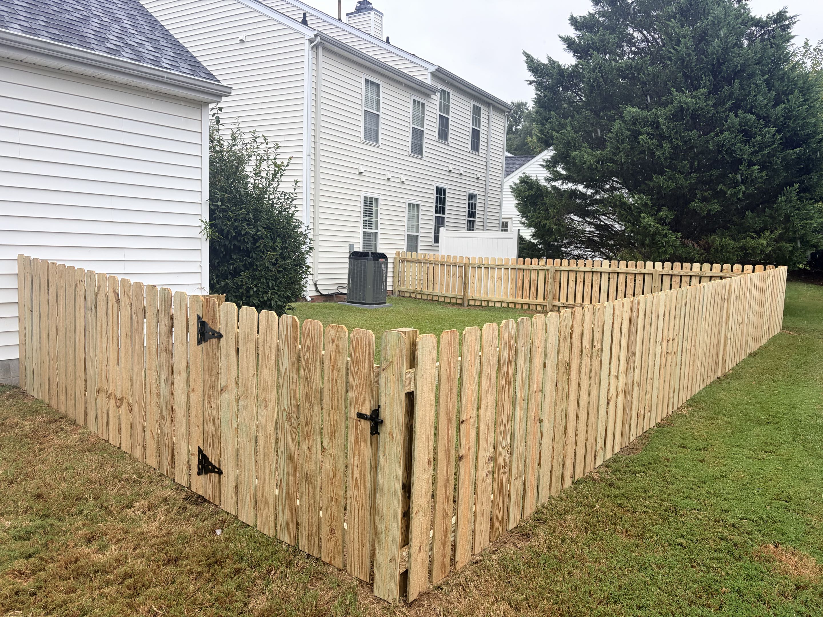Apex, NC - A 4-foot high wood picket fence was installed, spanning 80 linear feet to ensure the security of pets. The project included the precise measurement and layout of the fence, followed by the careful selection and cutting of high-quality wood pickets. Each picket was meticulously installed, ensuring a uniform appearance and robust structure. A single gate was incorporated into the design, providing convenient access while maintaining the fence's integrity. The installation process involved securing the fence posts into the ground, ensuring stability and longevity. Attention to detail was paramount, resulting in a visually appealing and functional fence that meets the client's needs for pet security.