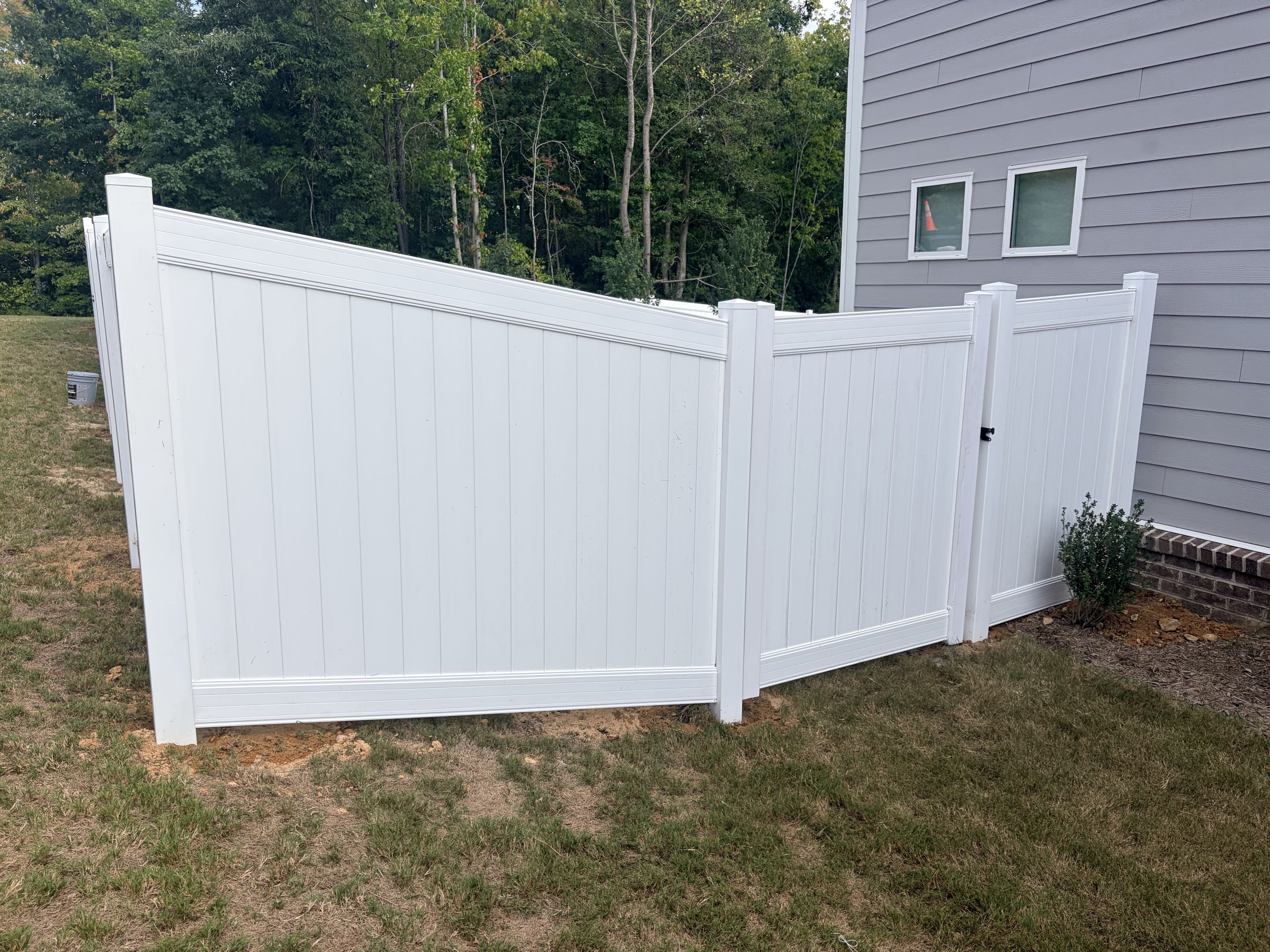Knightdale, NC - Our team successfully completed the installation of a 230-linear-foot white vinyl privacy fence, standing 6 feet tall, for a family. The project included the precise measurement, cutting, and installation of each section to ensure a seamless and sturdy structure. Two custom gates were also installed, providing convenient access while maintaining the fence's aesthetic appeal. The vinyl material was chosen for its durability and low maintenance, ensuring the fence will remain beautiful for years to come. Attention to detail was paramount, resulting in a flawless finish that enhances the family's outdoor space.