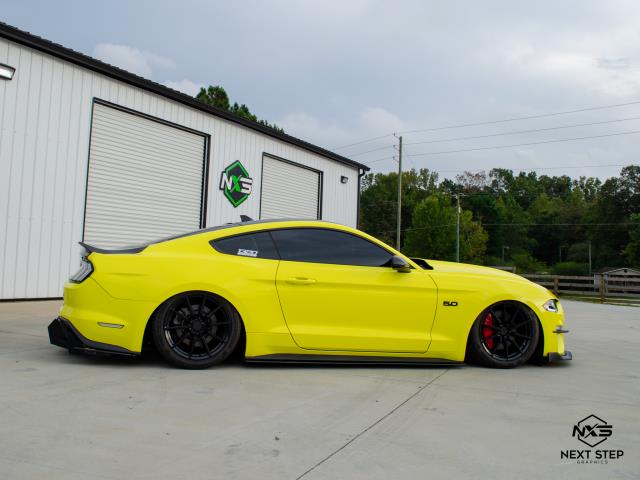 We transformed this Ford Mustang with a complete color change from gray to yellow, with a carbon fiber roof wrap delivering a bold, high-impact finish that amplifies the car's stance and styling. The wrap was precision-installed using premium cast vinyl, selected for its durability, conformability, and clean removability. Our preparation process included full surface decontamination, emblem removal, and panel alignment for seamless coverage. Installation techniques included heat application and tension mapping to ensure contour conformity across body lines and curves. The coverage for this full exterior wrap included hood, roof, trunk, bumpers, and door handles.
This wrap not only elevates the Mustang's visual presence but also protects the OEM paint from chips, scratches, and sun damage, making it a functional upgrade with serious curb appeal.  We transformed this Ford Mustang with a complete color change from gray to yellow, with a carbon fiber roof wrap delivering a bold, high-impact finish that amplifies the car's stance and styling. The wrap was precision-installed using premium cast vinyl, selected for its durability, conformability, and clean removability. Our preparation process included full surface decontamination, emblem removal, and panel alignment for seamless coverage. Installation techniques included heat application and tension mapping to ensure contour conformity across body lines and curves. The coverage for this full exterior wrap included hood, roof, trunk, bumpers, and door handles.
This wrap not only elevates the Mustang's visual presence but also protects the OEM paint from chips, scratches, and sun damage, making it a functional upgrade with serious curb appeal.