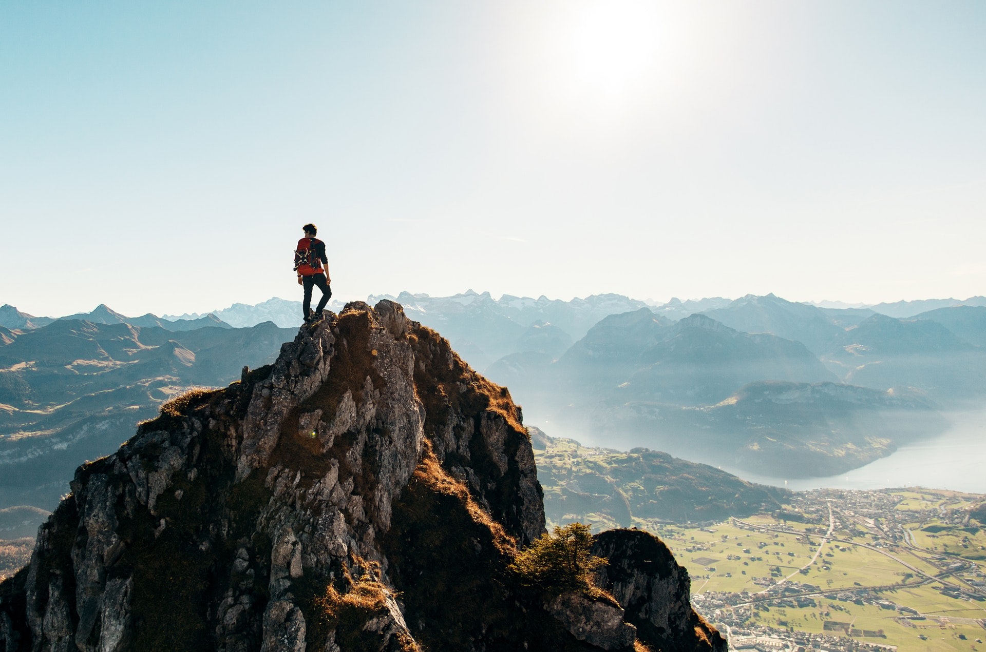 Climbing a mountain with a city below.