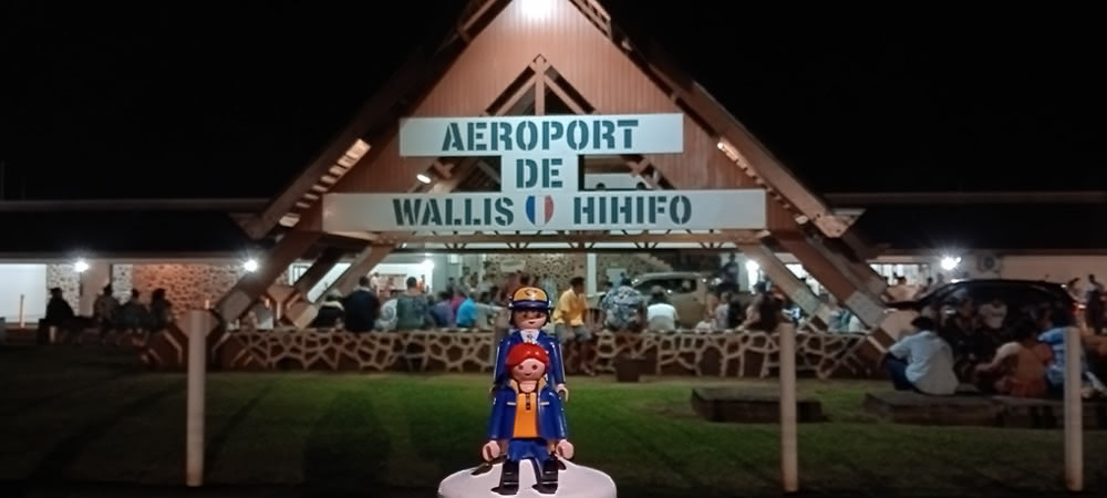Small island airport on Wallis at dawn, with locals gathered outside the terminal building