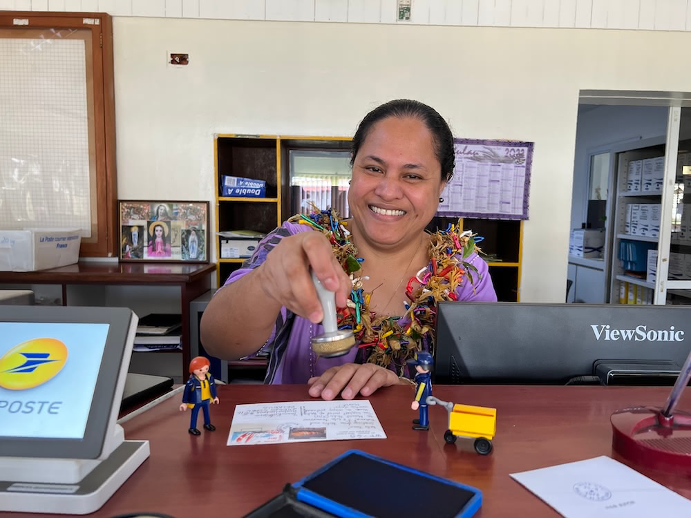 Wallis post office worker wearing a traditional flower garlands and smiling