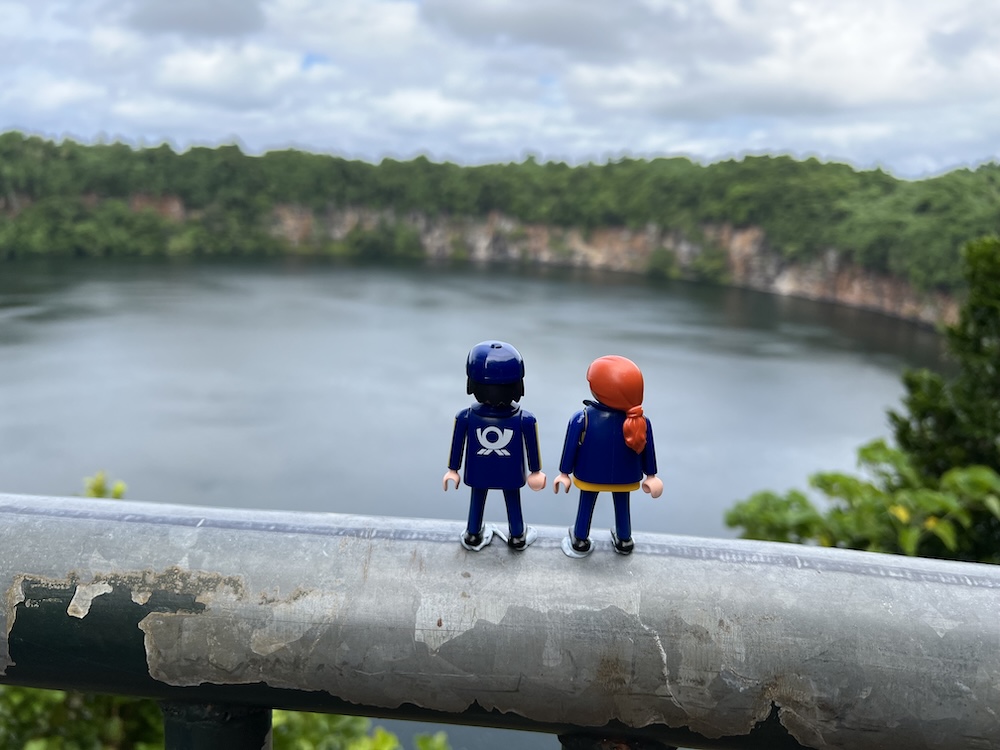 View of Lake Lalolalo, a round crater lake surrounded by dense green forest on Wallis