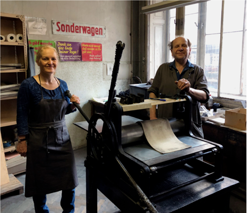 A photo of two people with some engraving equipment