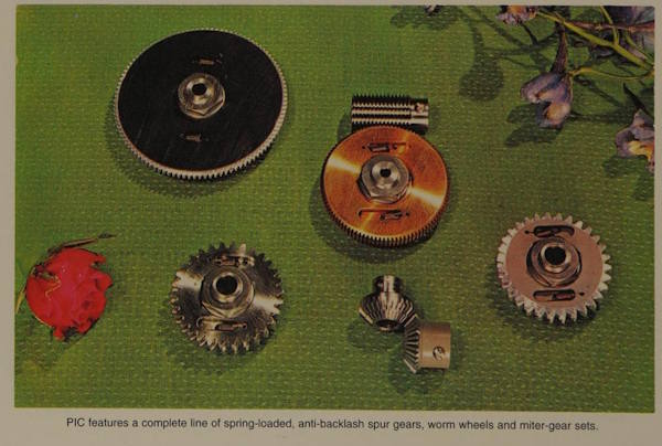 A postcard showing gears, with text saying PIC features a complete line of spring-loaded, anti-backlash spur gears, worm wheels and miter-gear sets; there are flowers along with the gears