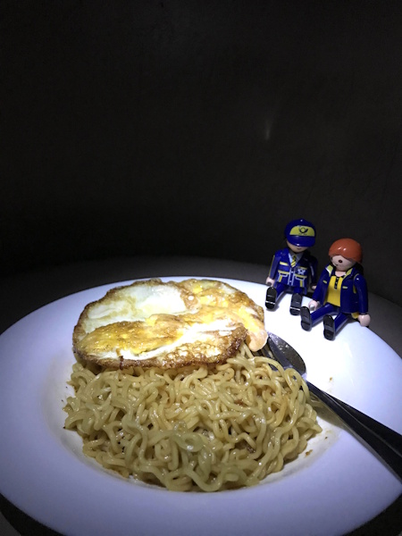 The Little Mail Carriers eat a simple dinner with noodles by torchlight