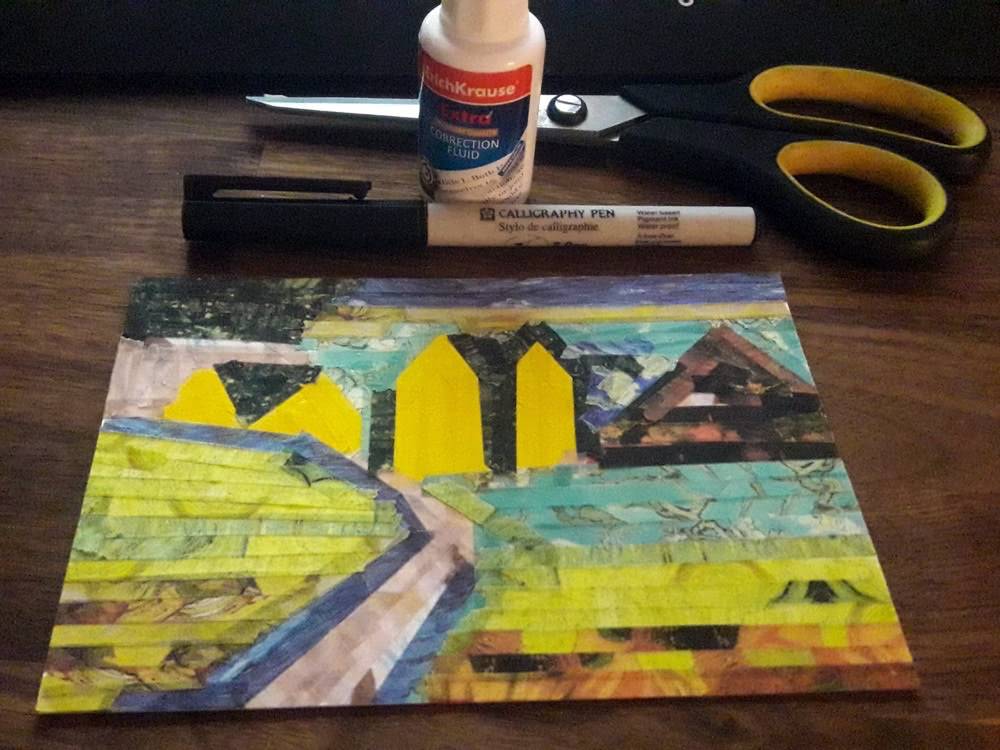 Fourth step of a washi tape postcard, with scissors, correction fluid and a pen beside the nearly finished landscape.