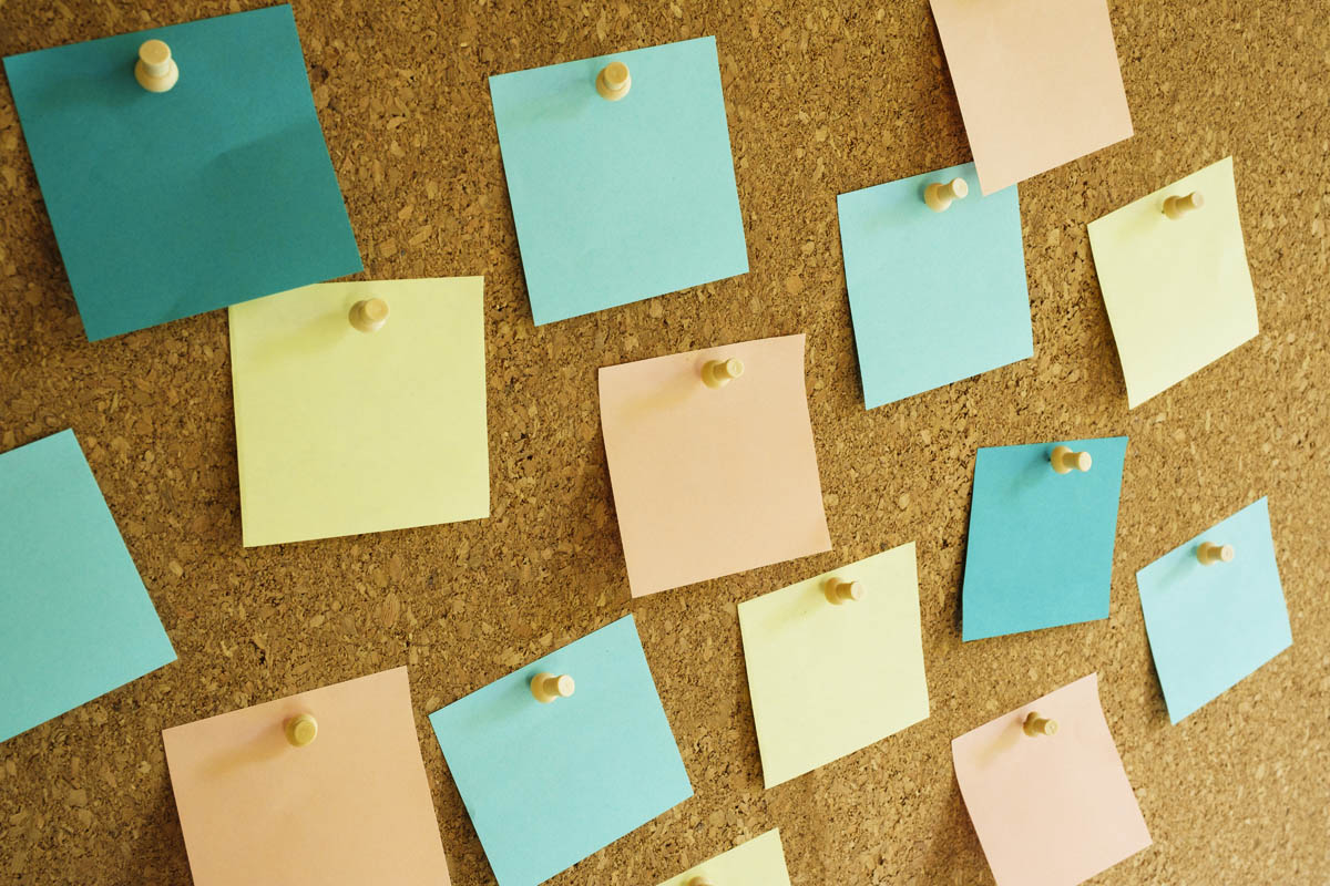 Closeup of multi colored adhesive notes on bulletin board