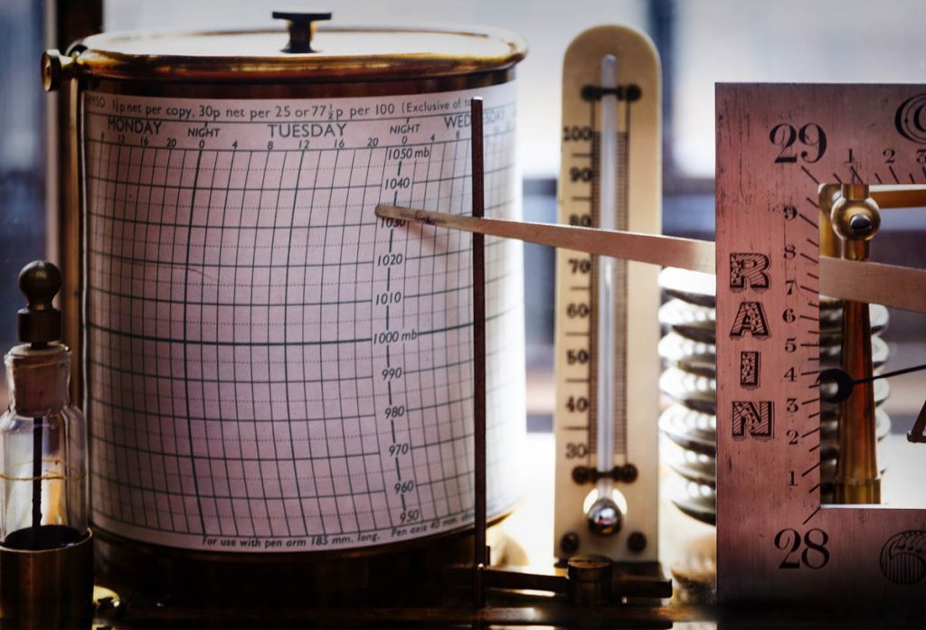 Rain gauge recorder with graph paper and pointer during rainfall