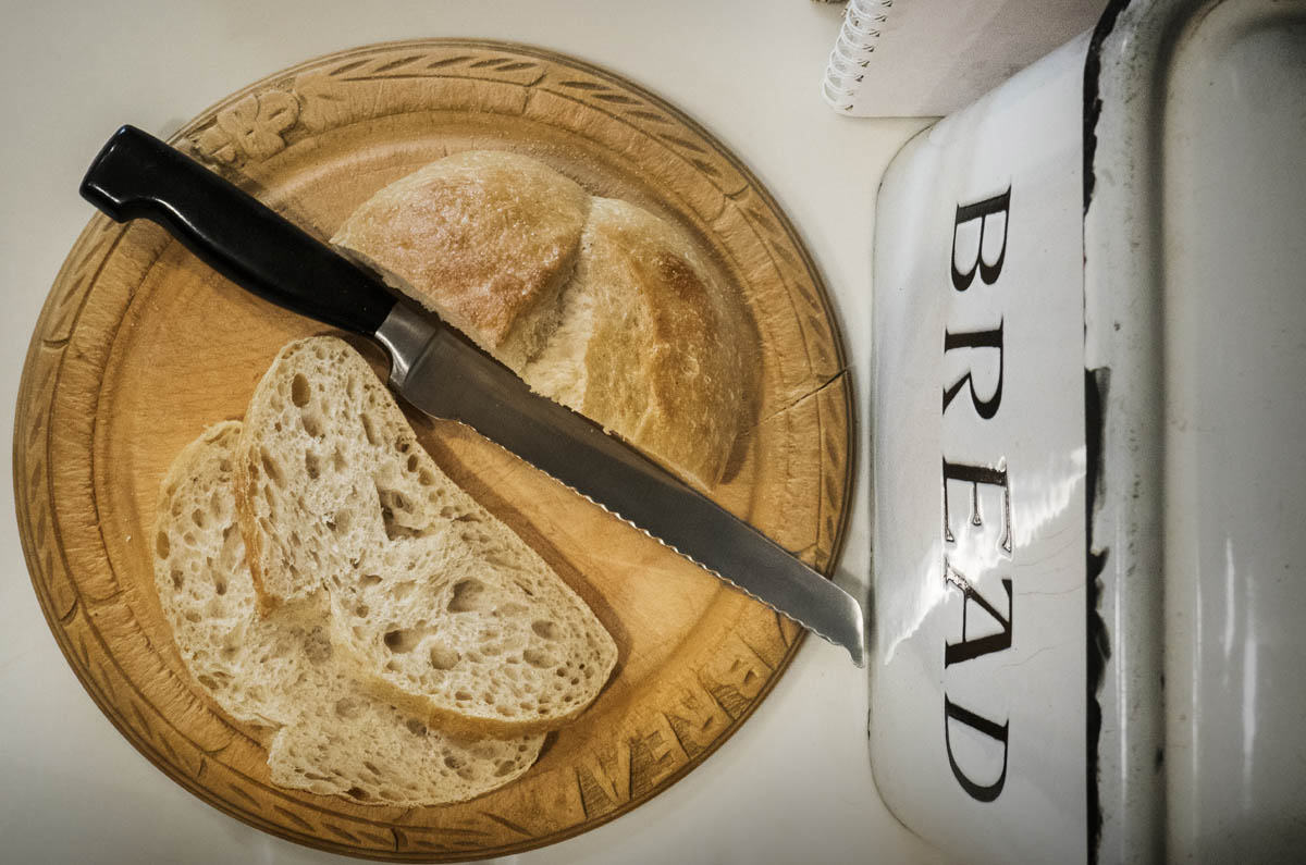Overhead view of bread and knife on wooden cutting board StockFreedom