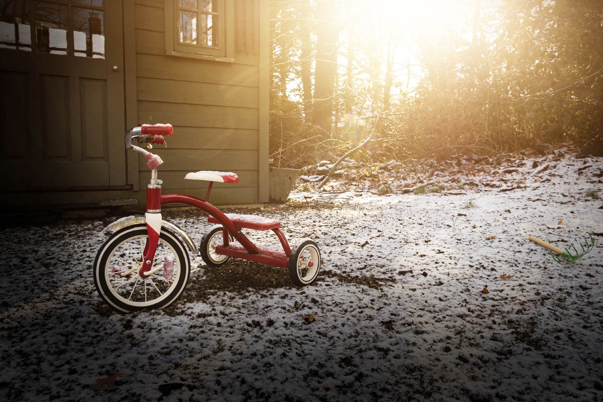Red tricycle on snow covered yard StockFreedom Premium Stock