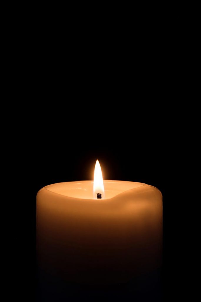 Vertical view of a candle against a black background StockFreedom
