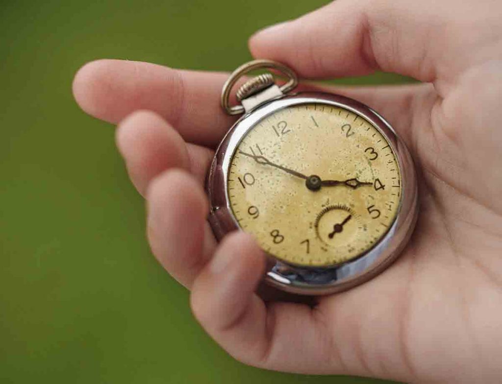 Closeup of hand holding pocket watch StockFreedom Premium Stock