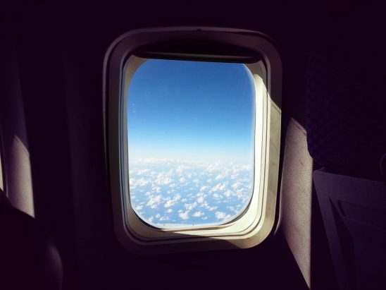 Free stock photo Airplane window with sky and puffy clouds