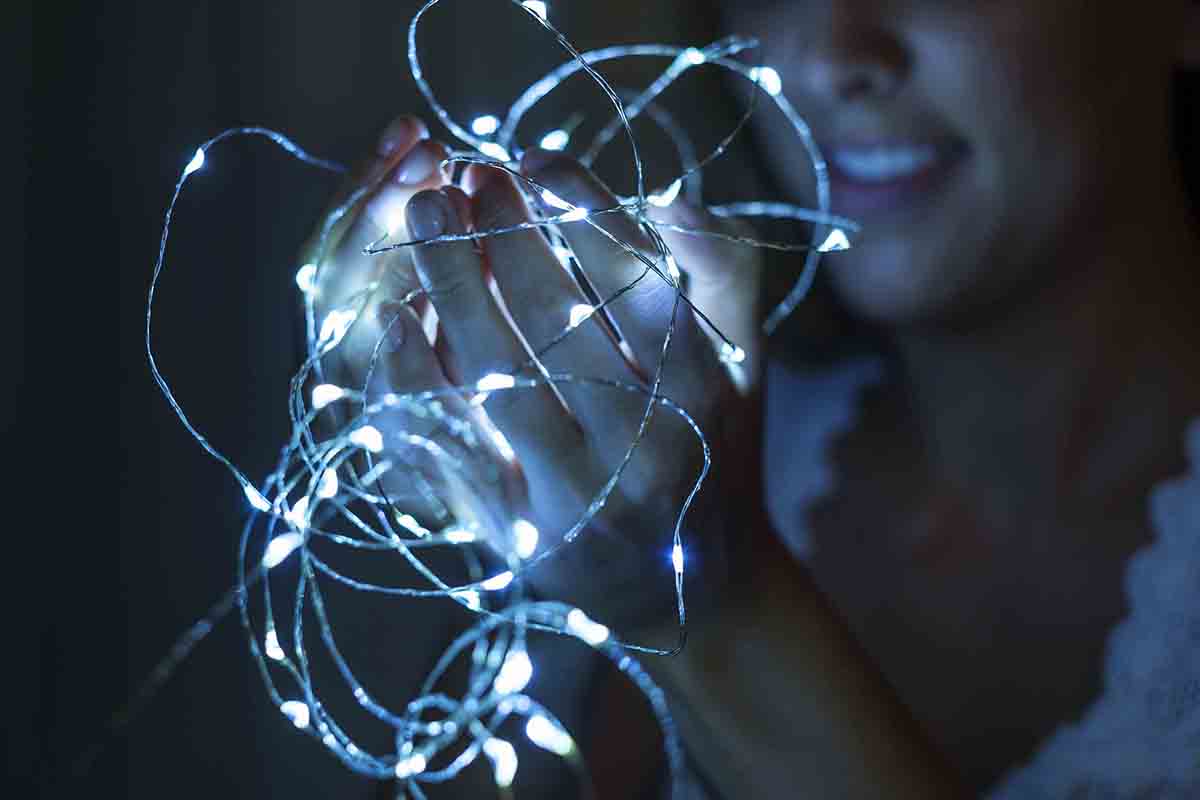 Closeup of hands holding strand of lights StockFreedom Premium