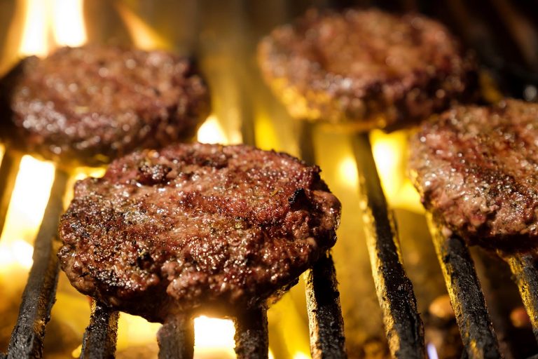 Hamburgers cooking on a charcoal grill StockFreedom Premium Stock