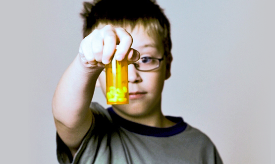 Boy handing over medication bottle