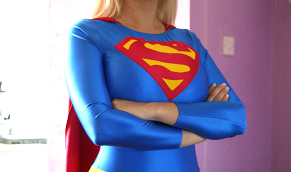 Supergirl with her arms folded across her breasts