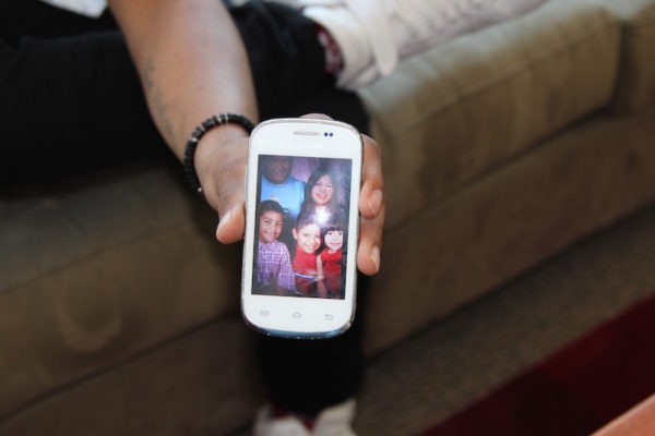 Christian Enriquez, 18, shows a photo of his family before his mother left and his father was deported to Mexico.