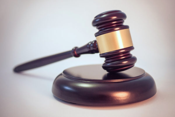 a gavel, head resting at a bit of an angle on a round stand