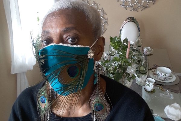 Nezzie Shabazz and her peacock mask with matching earrings.