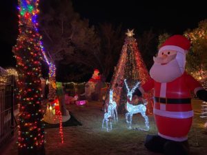 Front yard with light-up Christmas displays, including reindeer and Santa.