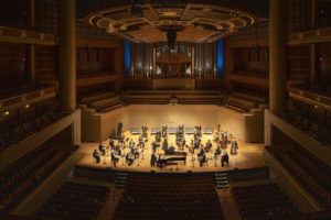 a concert hall with the dallas symphony performing in a socially distant concert
