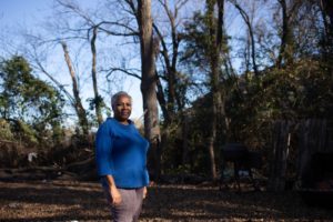 Marsha Jackson stands in her backyard, with Shingle Mountain, the toxic waste dump, in the background.