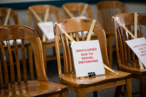 seats in a courthouse marked with tape and signs asking people to not sit there because of social distancing during the coronavirus pandemic