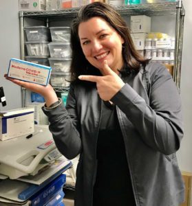 a nurse with a packet of COVID-19 vaccine doses