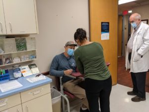 a man getting a COVID-19 vaccine in a doctor's office
