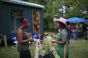 two women at a farmstand with plants